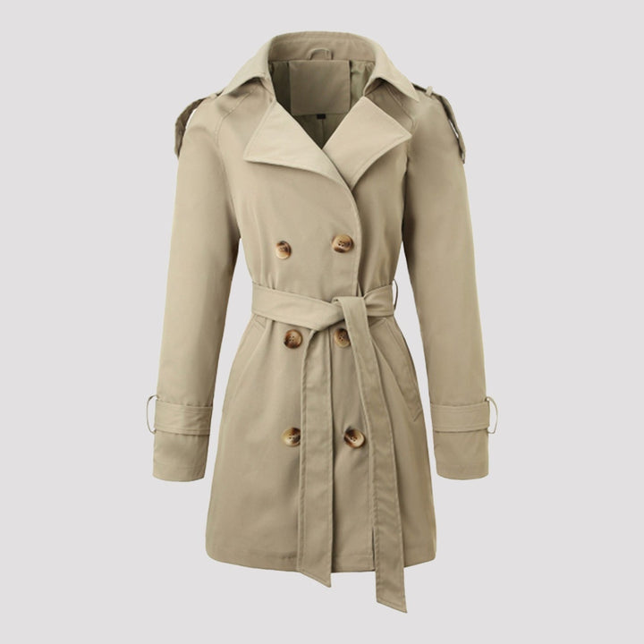 Trench lungo doppiopetto classico da donna beige con cintura, ideale per autunno e primavera.