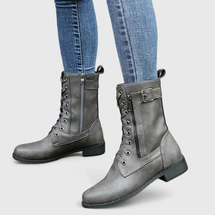 Vista frontale stivali combat donna neri con stringhe e suola robusta, perfetti per l'autunno.