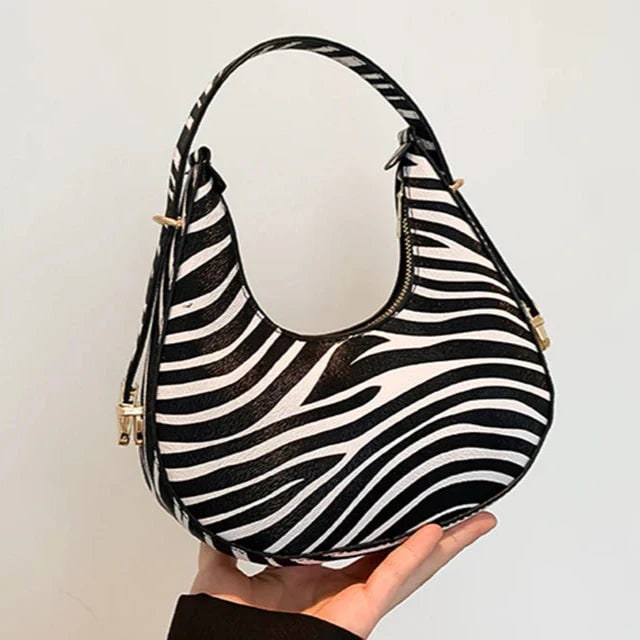 Borsa a spalla da donna, forma mezzaluna, in ecopelle con audace stampa animale. Perfetta per ogni occasione.