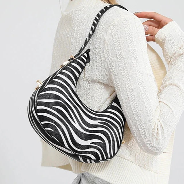 Borsa a spalla chic e di tendenza, a mezzaluna, per donna con stampa animale. Completa il tuo look.