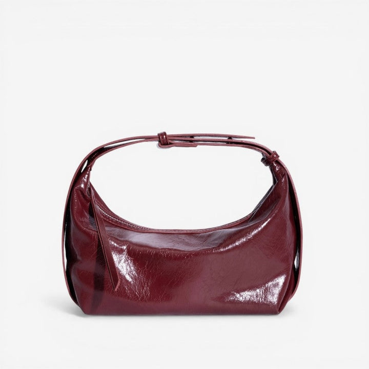 Dettaglio borsa donna in ecopelle lucida increspata, finitura moderna e di alta qualità.