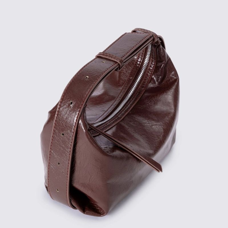Primo piano della texture increspata di borsa a mezzaluna in ecopelle lucida, un tocco di classe.