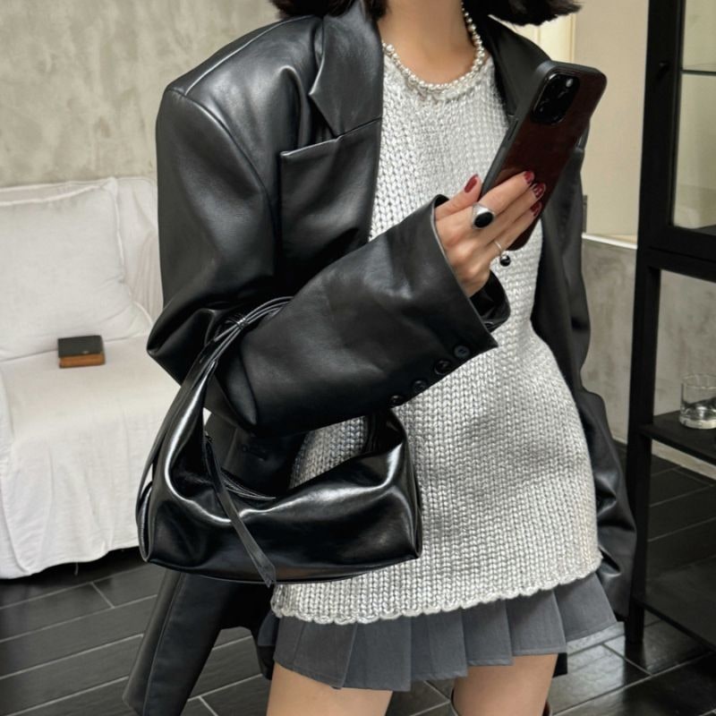 Borsa donna versatile in ecopelle lucida, con la sua forma a mezzaluna e texture increspata distintiva.