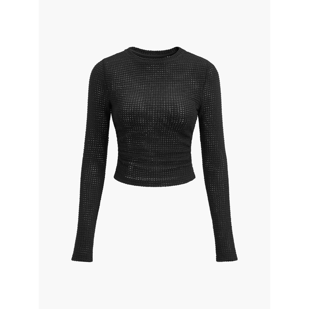 Top crop donna a maniche lunghe color apricot, collo rotondo, vestibilità aderente, abbigliamento femminile essenziale.