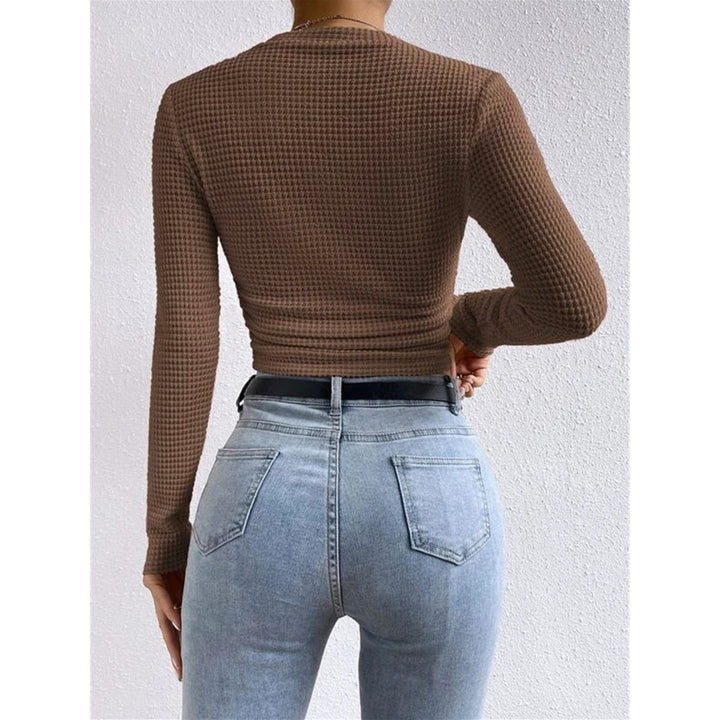 Top donna a maniche lunghe aderente nero, collo rotondo, taglio crop per un look giovanile e alla moda.