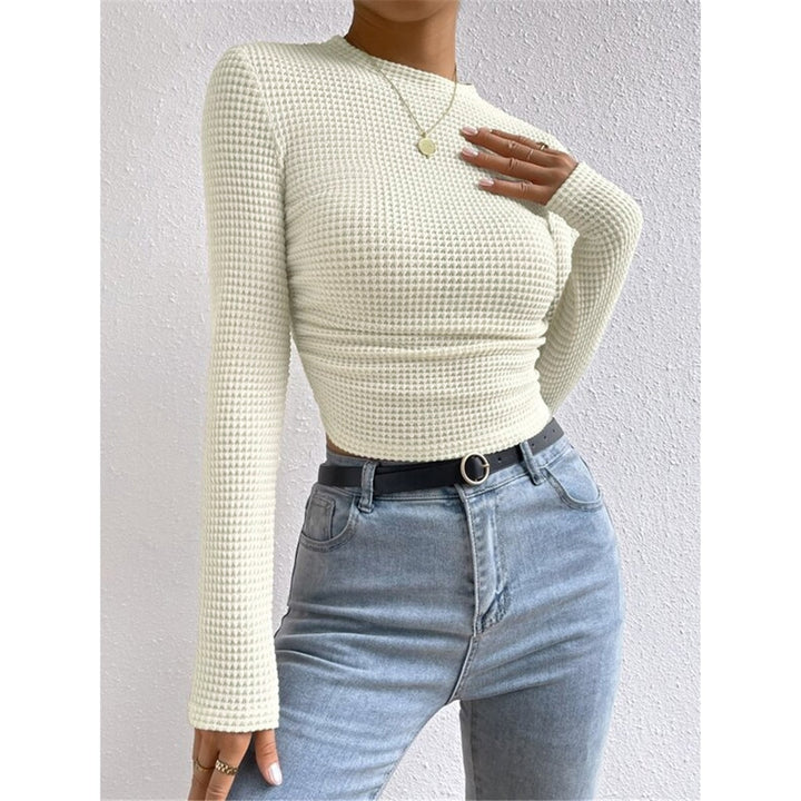 Top crop da donna in maglia a maniche lunghe color apricot, vestibilità aderente e scollo rotondo, casual chic.