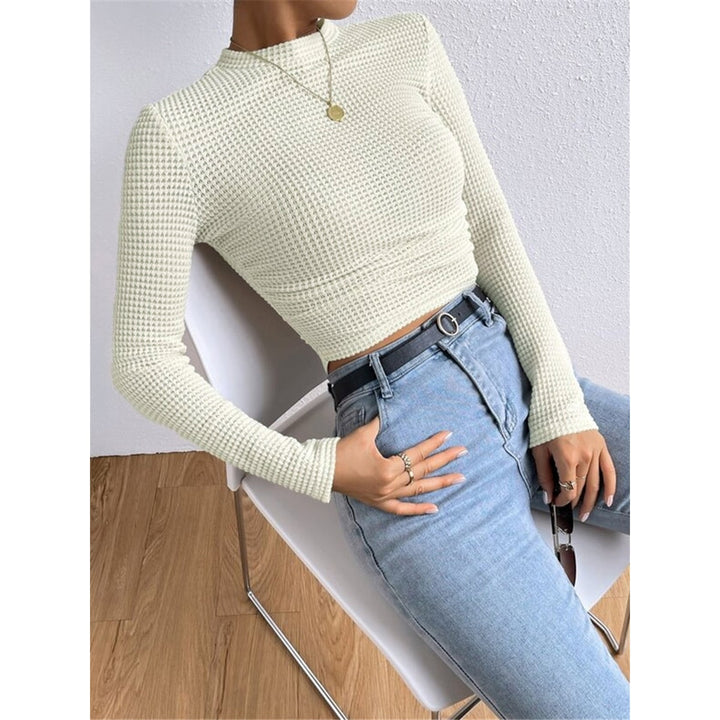 Modello frontale di top donna crop marrone a maniche lunghe, design aderente e scollo tondo, versatile e moderno.