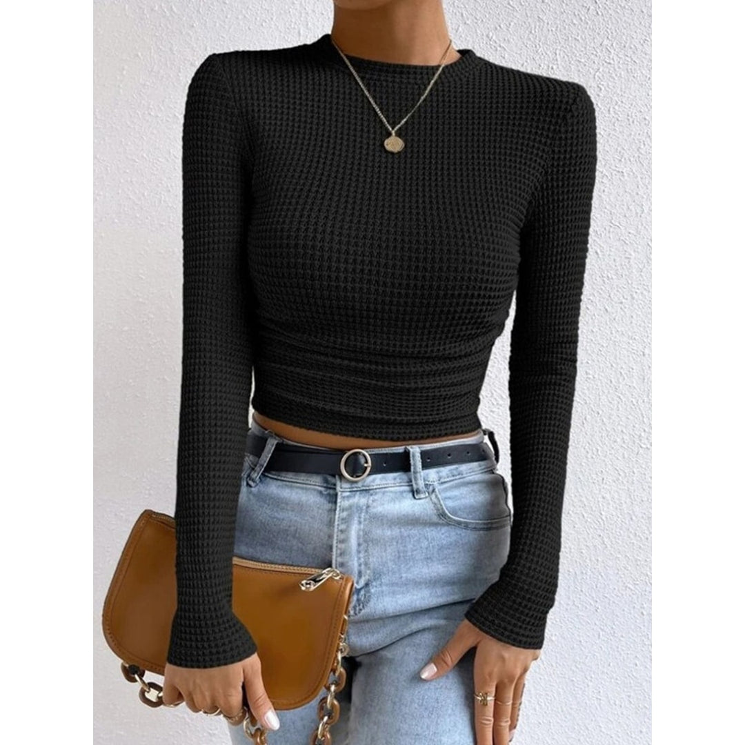 Top femminile crop marrone con maniche lunghe e scollo rotondo, vestibilità aderente per comfort e stile.