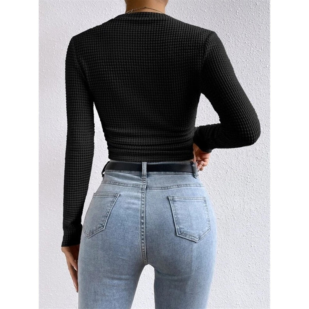 Dettaglio schiena di top donna aderente blu navy, crop a maniche lunghe, collo rotondo, minimal e chic.