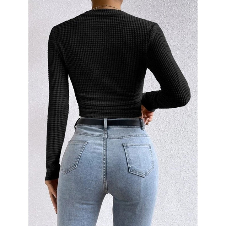 Dettaglio schiena di top donna aderente blu navy, crop a maniche lunghe, collo rotondo, minimal e chic.