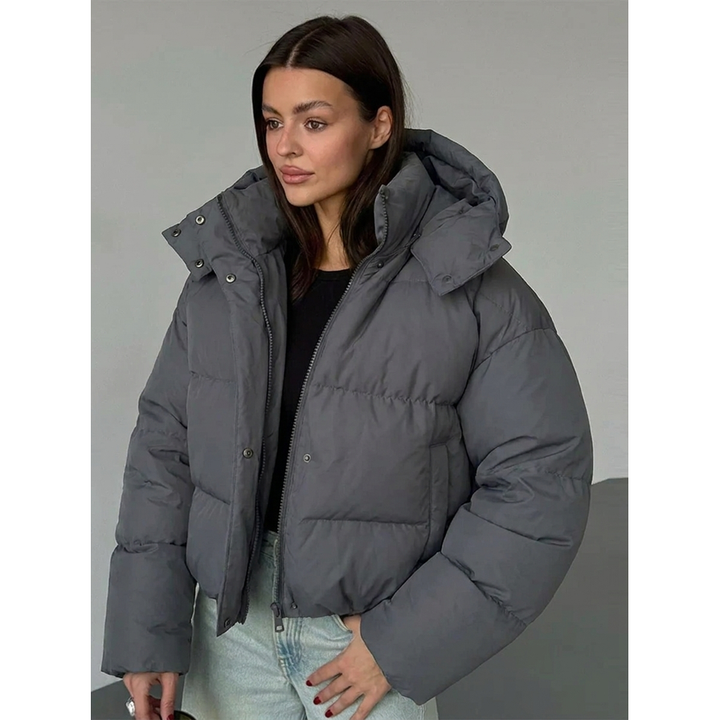 Giacca piumino corta donna con cappuccio oversize, ideale per outfit invernali casual e alla moda.