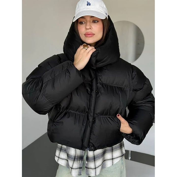 Elegante giacca piumino corta da donna, calda e trapuntata, con cappuccio oversize per un look quotidiano.