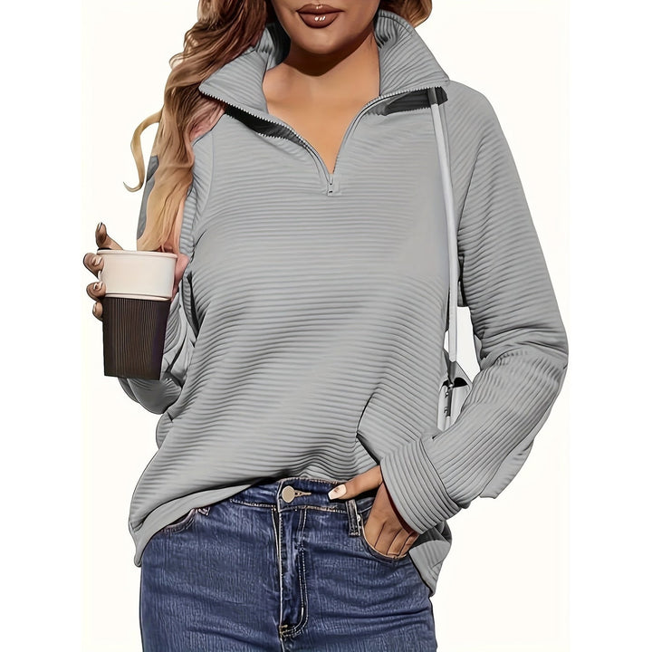 Moda donna autunnale: felpa a mezzo zip, collo alto, tessuto testurizzato. Casual e confortevole.