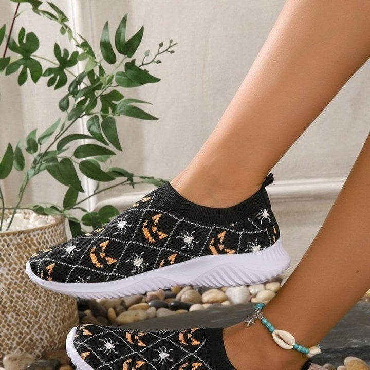 Comode scarpe slip-on donna per Halloween. Design autunnale con zucche, pipistrelli e ragnatele. Stile casual e moda.