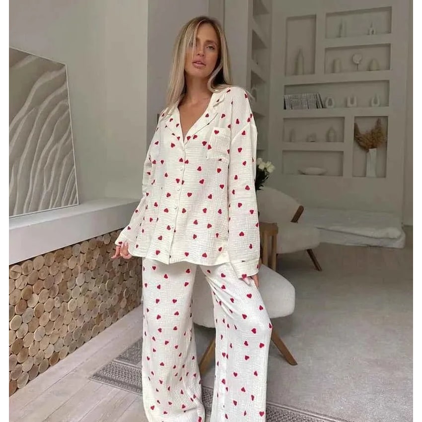 Comodo pigiama due pezzi da donna in cotone, con motivo a cuori rossi, perfetto per un relax cozy.