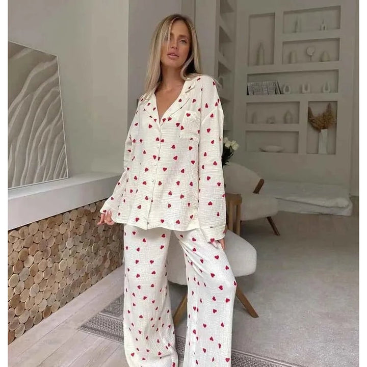 Comodo pigiama due pezzi da donna in cotone, con motivo a cuori rossi, perfetto per un relax cozy.