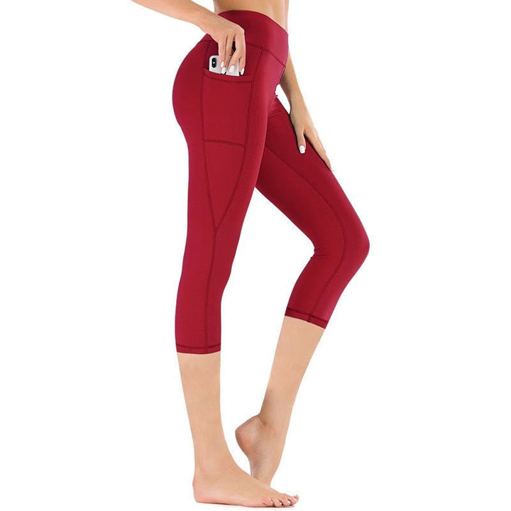 Donna che indossa leggings capri a vita alta con tasche, ideali per yoga, sport e attività fisica.