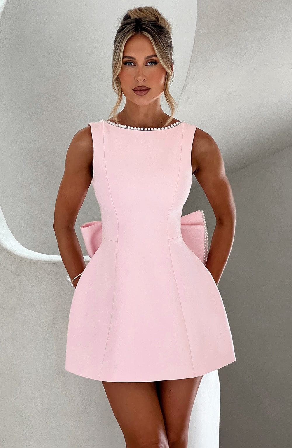 Mini abito cerimonia donna elegante con fiocco strutturato, perfetto per cocktail e feste autunnali.
