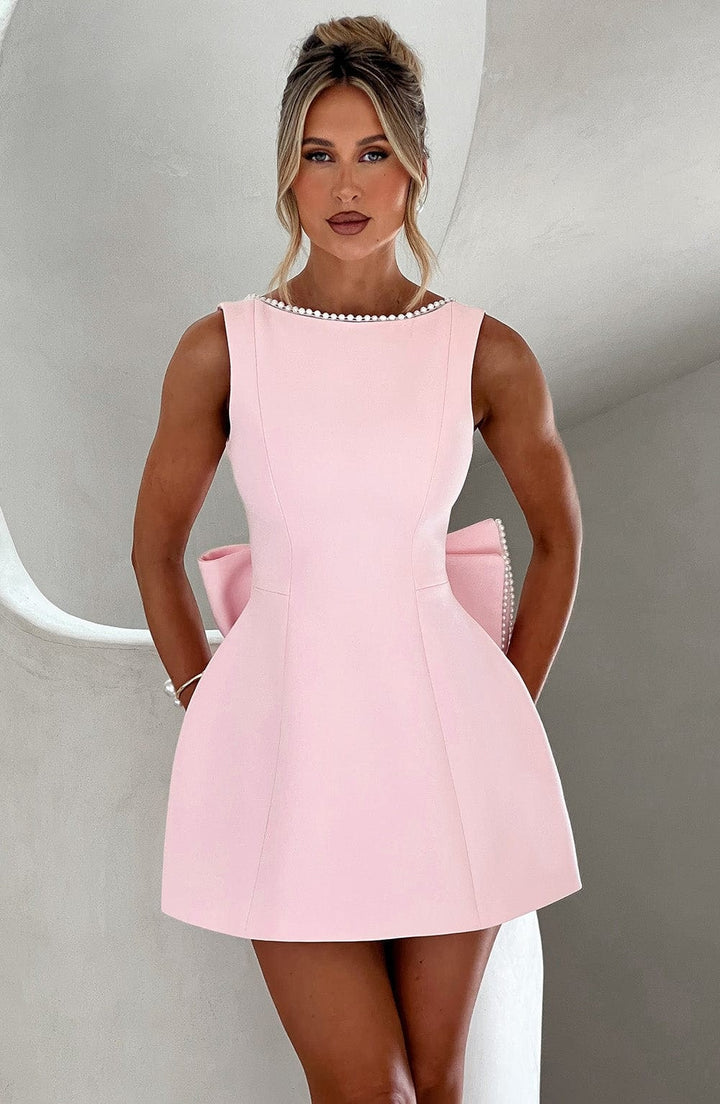 Mini abito cerimonia donna elegante con fiocco strutturato, perfetto per cocktail e feste autunnali.