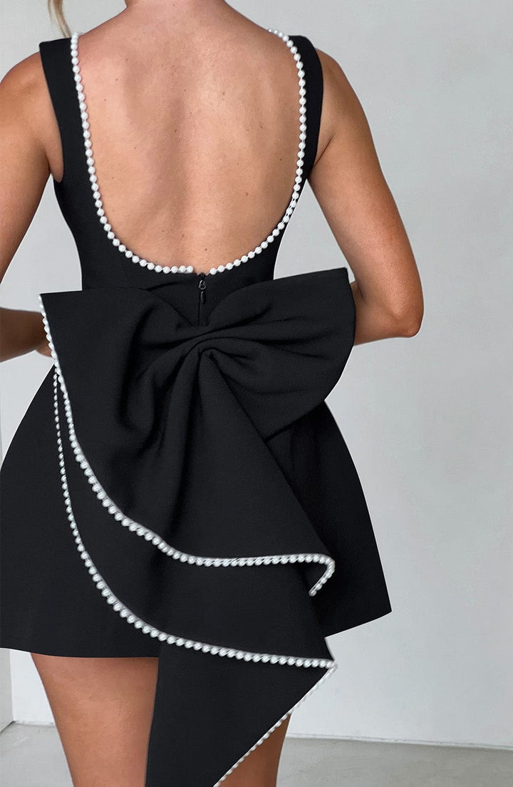 Vestito elegante donna per cerimonia autunnale, mini abito con fiocco strutturato e dettagli chic.