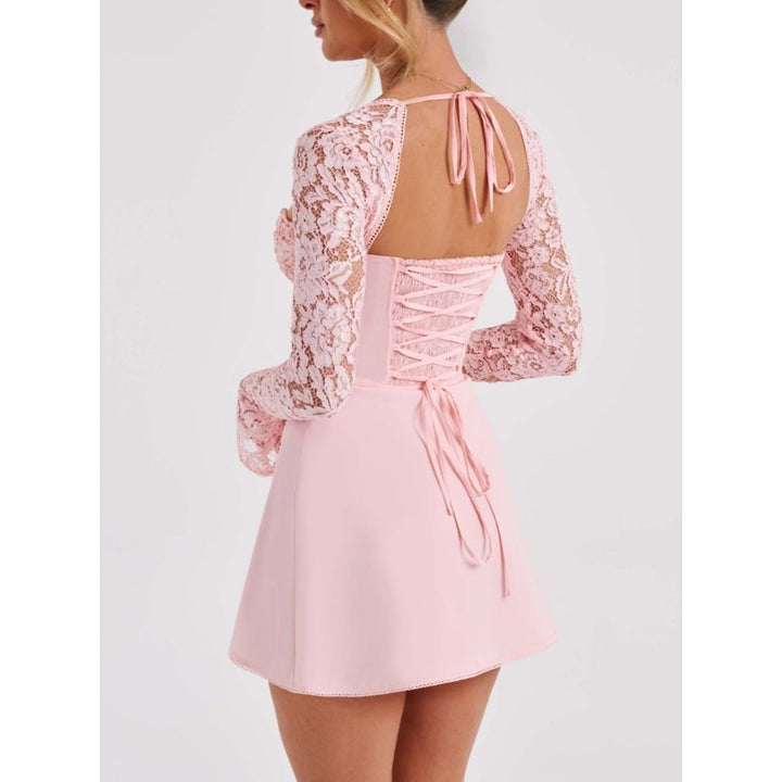 Abito da donna romantico in pizzo, mini cut, scollo a cuore, maniche lunghe e schiena con lacci a corsetto.