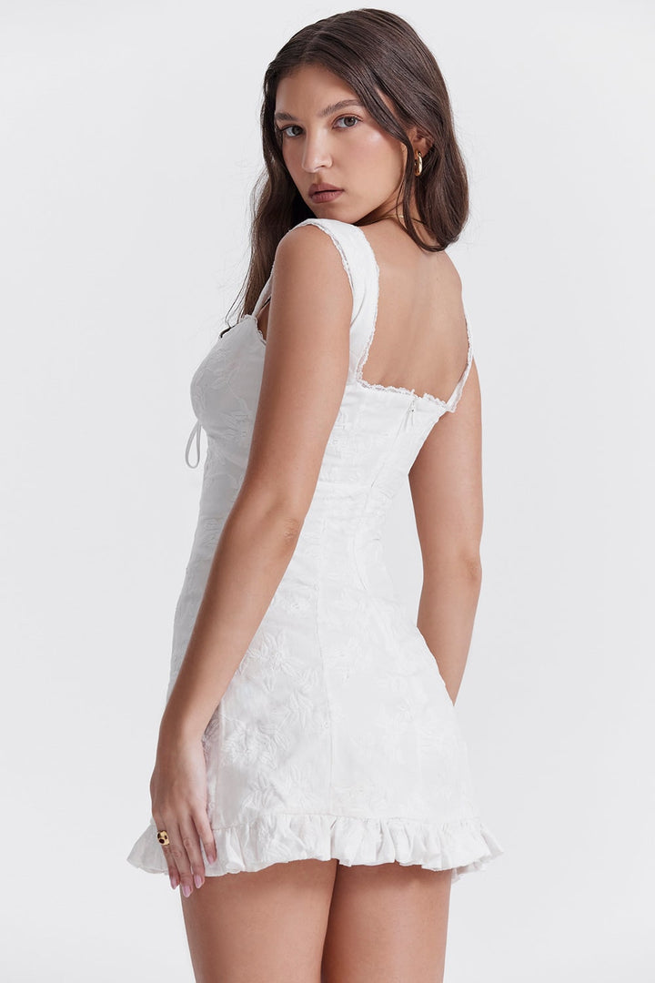 Elegante mini abito donna bianco, scollo a cuore, nodo frontale e balze delicate per un look raffinato.