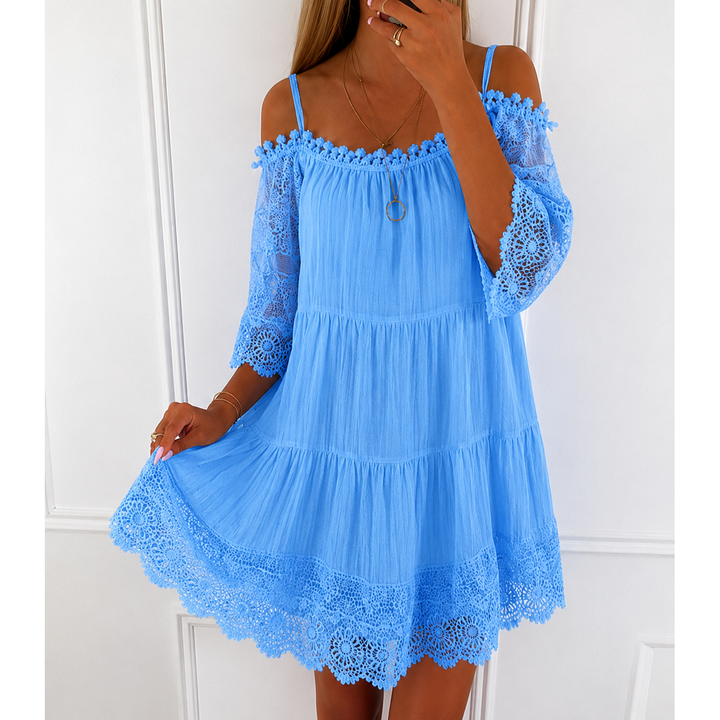 Abito mini donna versatile in pizzo con scollo off-shoulder e maniche a campana. Look estivo elegante.