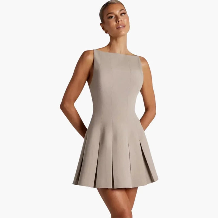 Mini abito donna elegante, plissettato, senza schienale, spalline sottili. Vestito corto moda primavera estate.