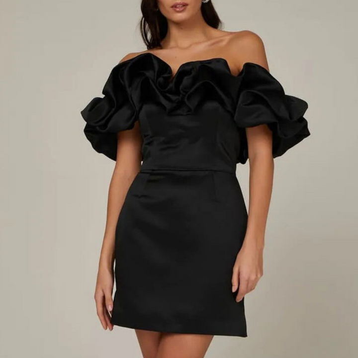 Elegante mini abito da festa donna con volant e spalle scoperte, ideale per cocktail o invitata matrimonio.