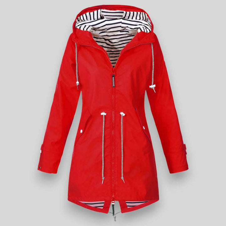 Giacca donna alla moda, antipioggia e con cappuccio, dotata di coulisse in vita per una vestibilità regolabile.