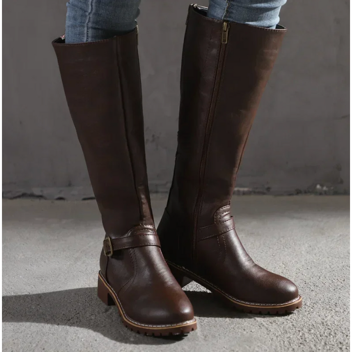 Stivali alti donna con cerniera laterale e cinturino decorativo. Scarpe al ginocchio ideali per look invernali casual-eleganti.