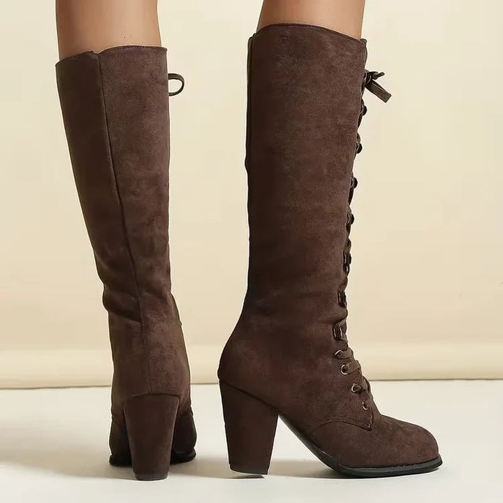 Stivali viola al ginocchio da donna, lacci decorativi, tacco largo. Calzature invernali alla moda.