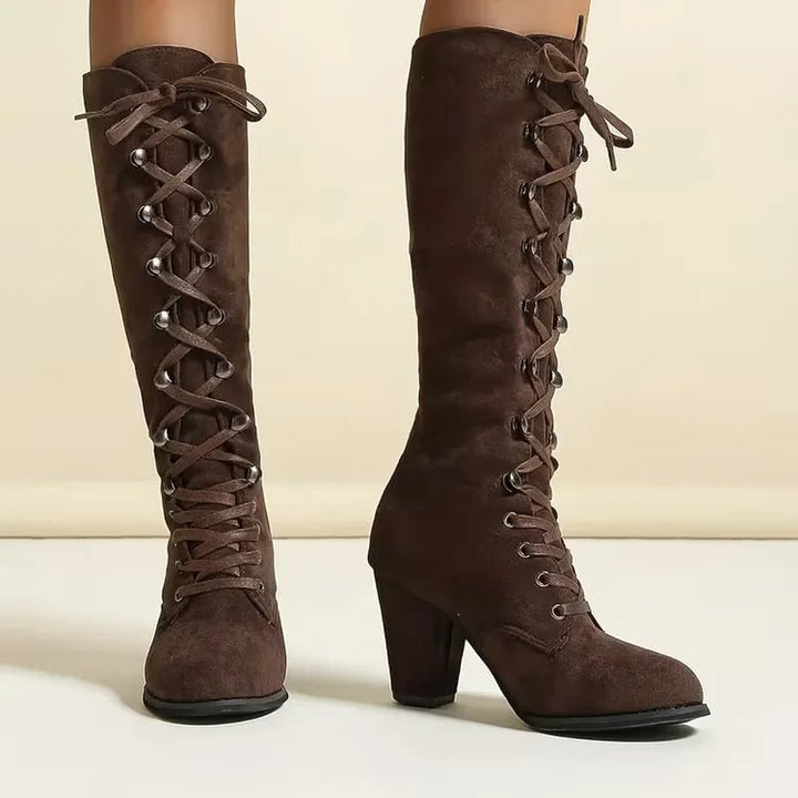 Stivali neri al ginocchio da donna, stile vintage, lacci e robusto tacco largo. Calzature invernali chic.