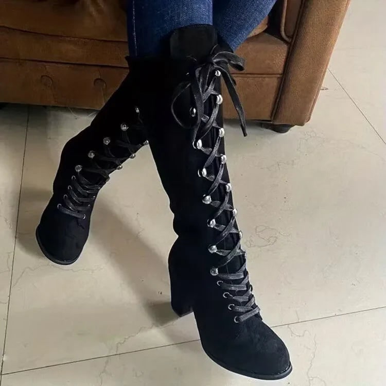 Stivali al ginocchio da donna con lacci, tacco largo e texture elegante. Stivali invernali, moda.