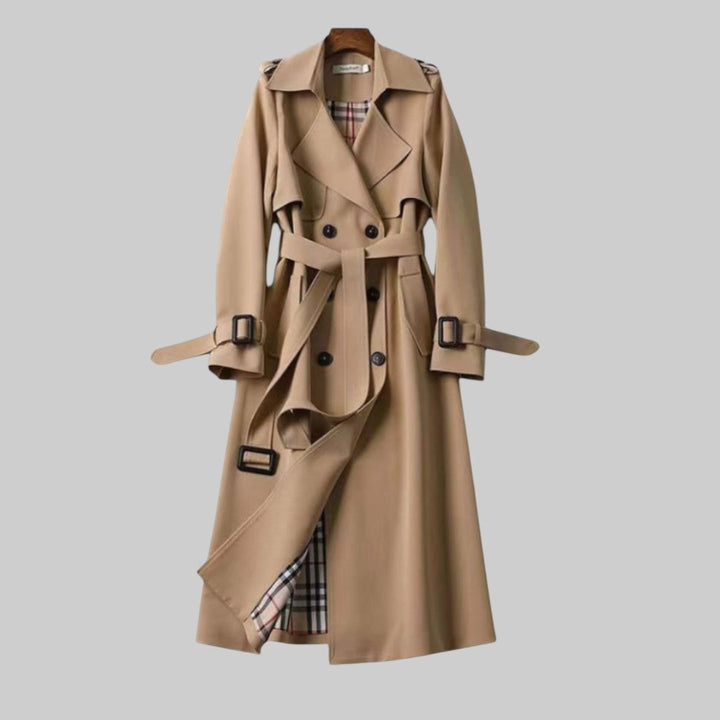 Trench donna lungo classico doppiopetto, con cintura in vita. Eleganza senza tempo per outerwear primaverile.