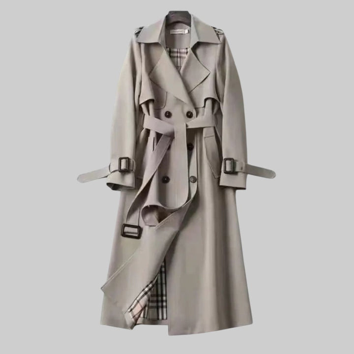 Trench da donna lungo e raffinato, con design doppiopetto e cintura che valorizza la figura. Ideale per ogni stile.
