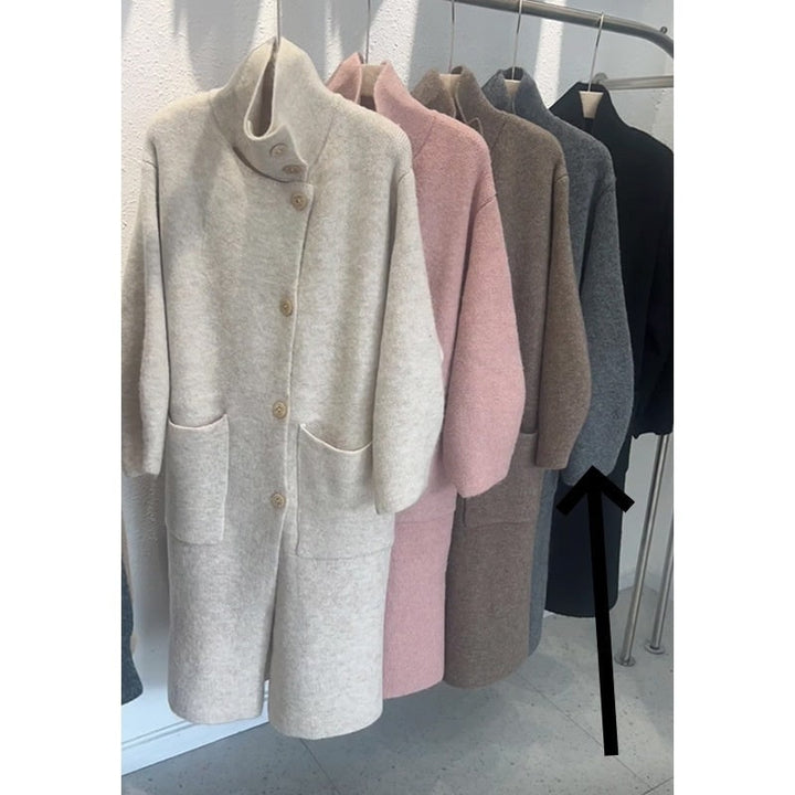 Donna indossa cardigan lungo oversize con collo ad imbuto e maniche a palloncino. Abbigliamento moda autunno inverno.