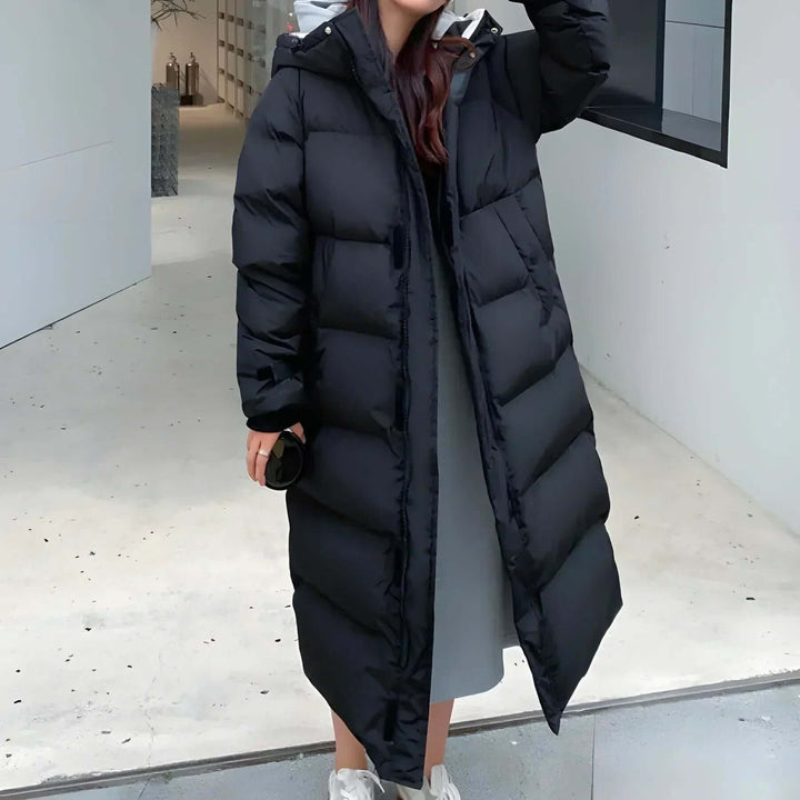 Piumino lungo da donna con cappuccio, design trapuntato elegante. Perfetto cappotto invernale caldo e casual per lei.