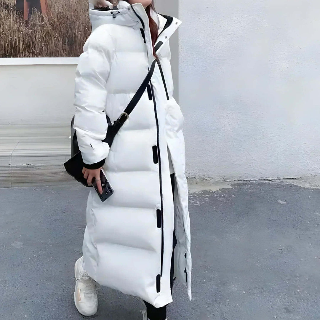 Giacca lunga trapuntata da donna con cappuccio, piumino caldo per protezione dal freddo. Ideale per outfit invernali.