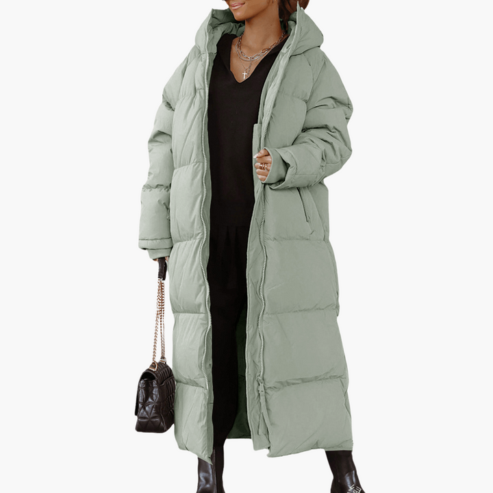Piumino lungo da donna trapuntato con cappuccio, caldo e alla moda. Cappotto invernale perfetto per stile casual.
