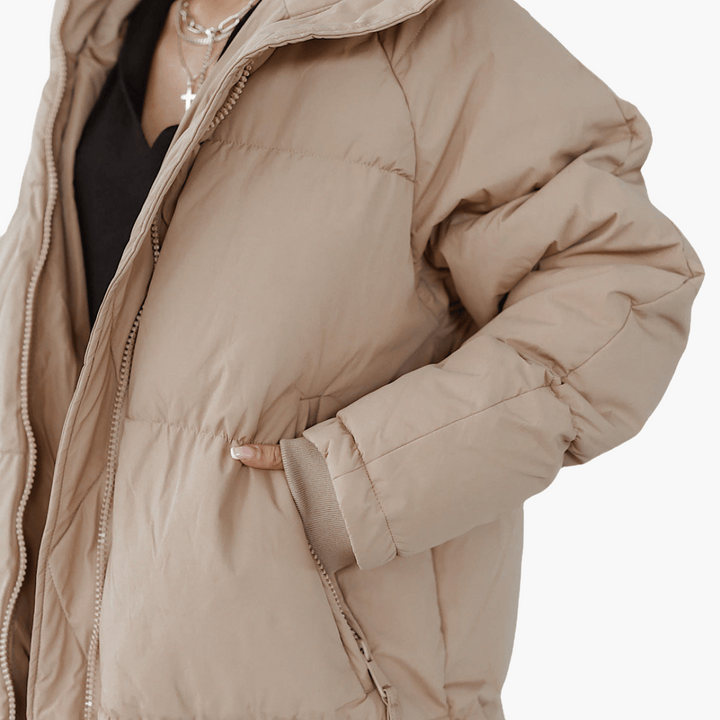 Must-have invernale: piumino lungo da donna trapuntato con cappuccio. Cappotto caldo e alla moda per l'inverno.