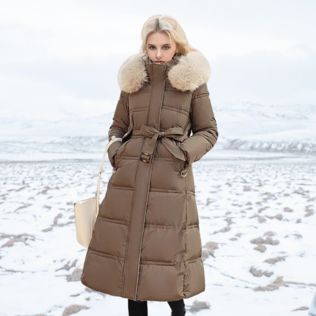 Primo piano: cappotto lungo donna invernale trapuntato con cappuccio in ecopelliccia. Caldo e di tendenza.