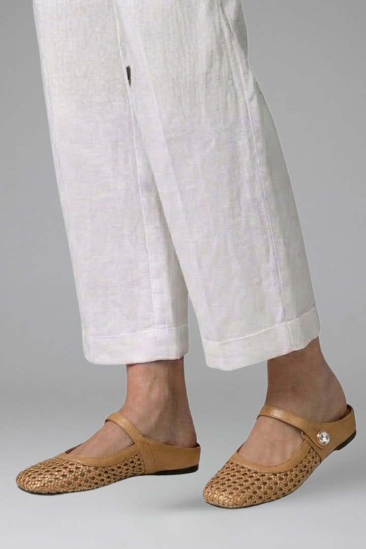 Donna che indossa mules Mary Jane slip-on intrecciate. Calzature eleganti e comode per la primavera-estate.