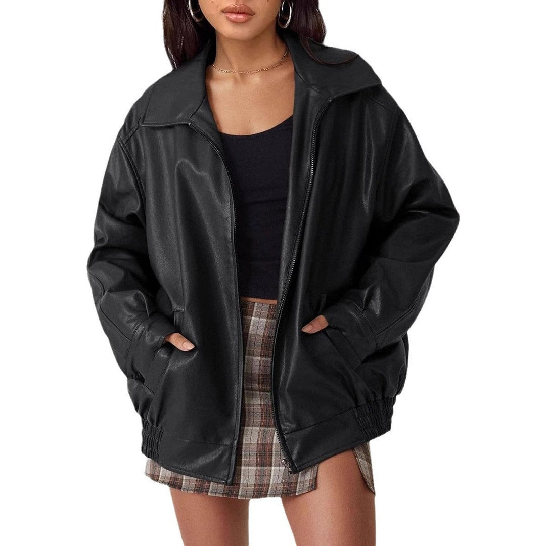 Donna indossa giacca bomber in pelle sintetica nera, look casual chic per autunno/inverno. Con zip e collo a camicia.