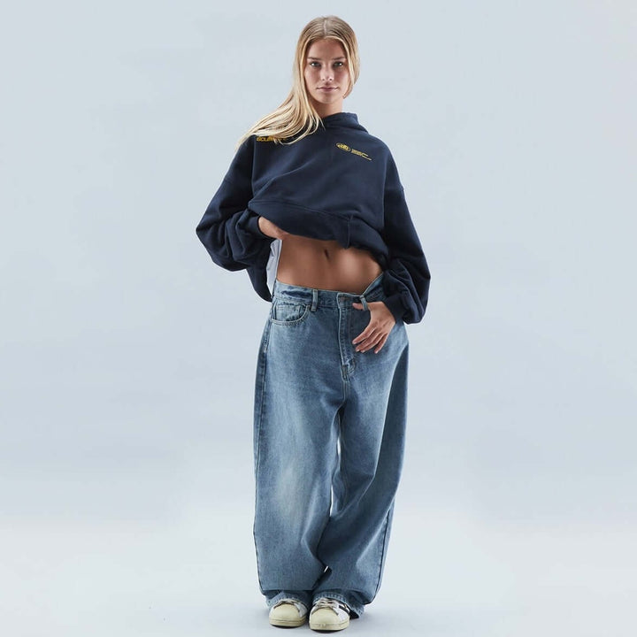 Felpa oversize donna grafica con cappuccio, spalla scesa, tasca a canguro, stile casual streetwear.