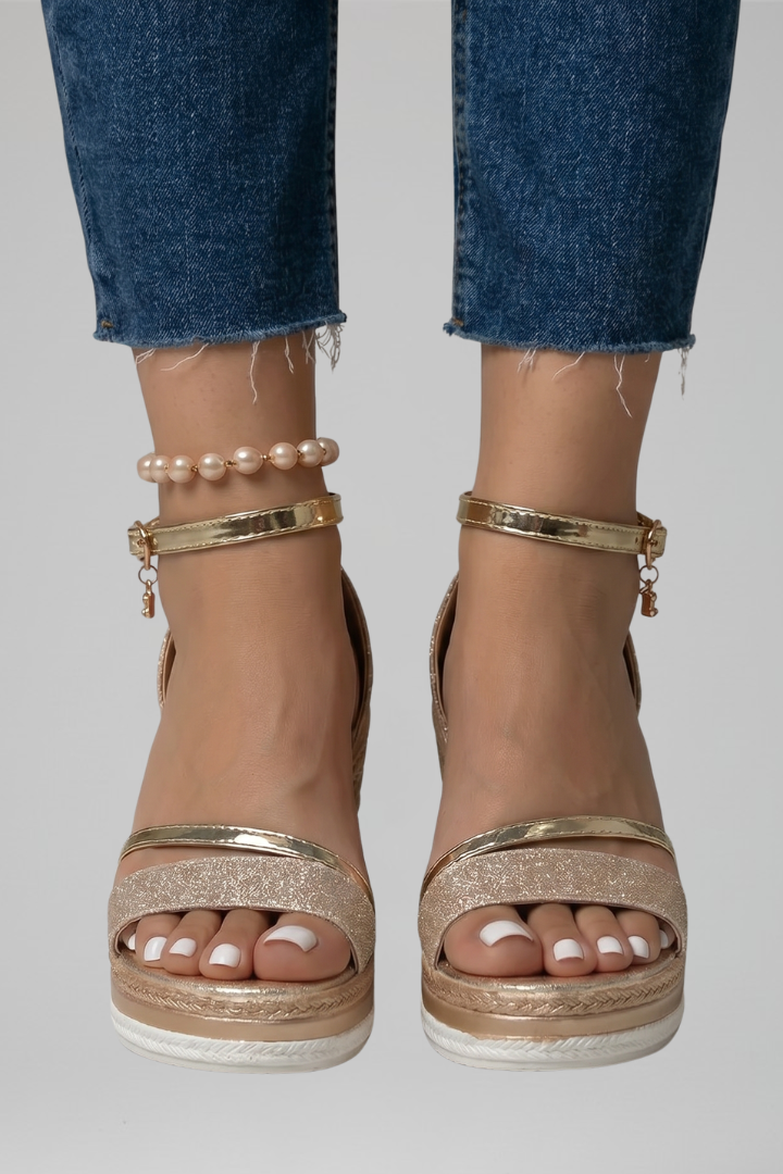 Sandali estivi scintillanti con zeppa platform da donna. Dettaglio cinturino alla caviglia e punta aperta glam.