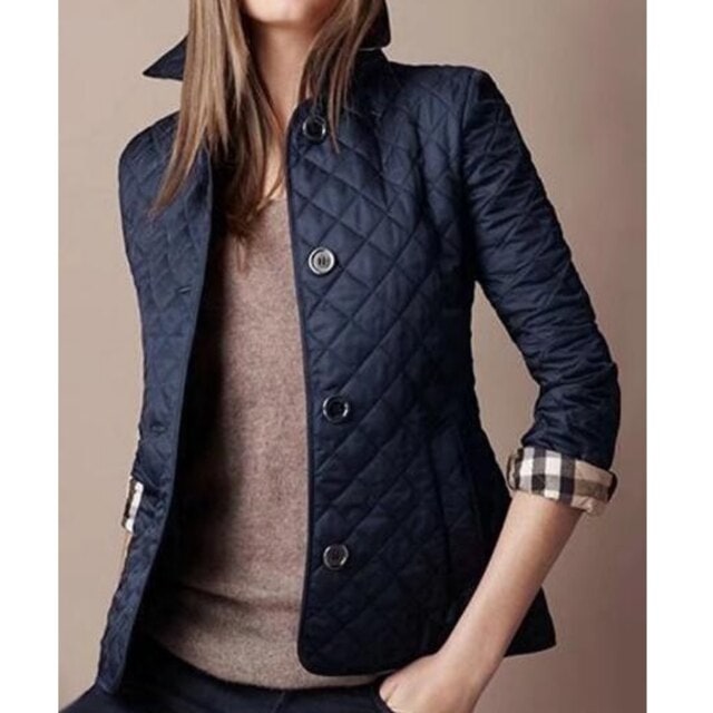 Elegante giacca trapuntata da donna con distintiva fodera scozzese, ideale per outfit autunno-primavera.
