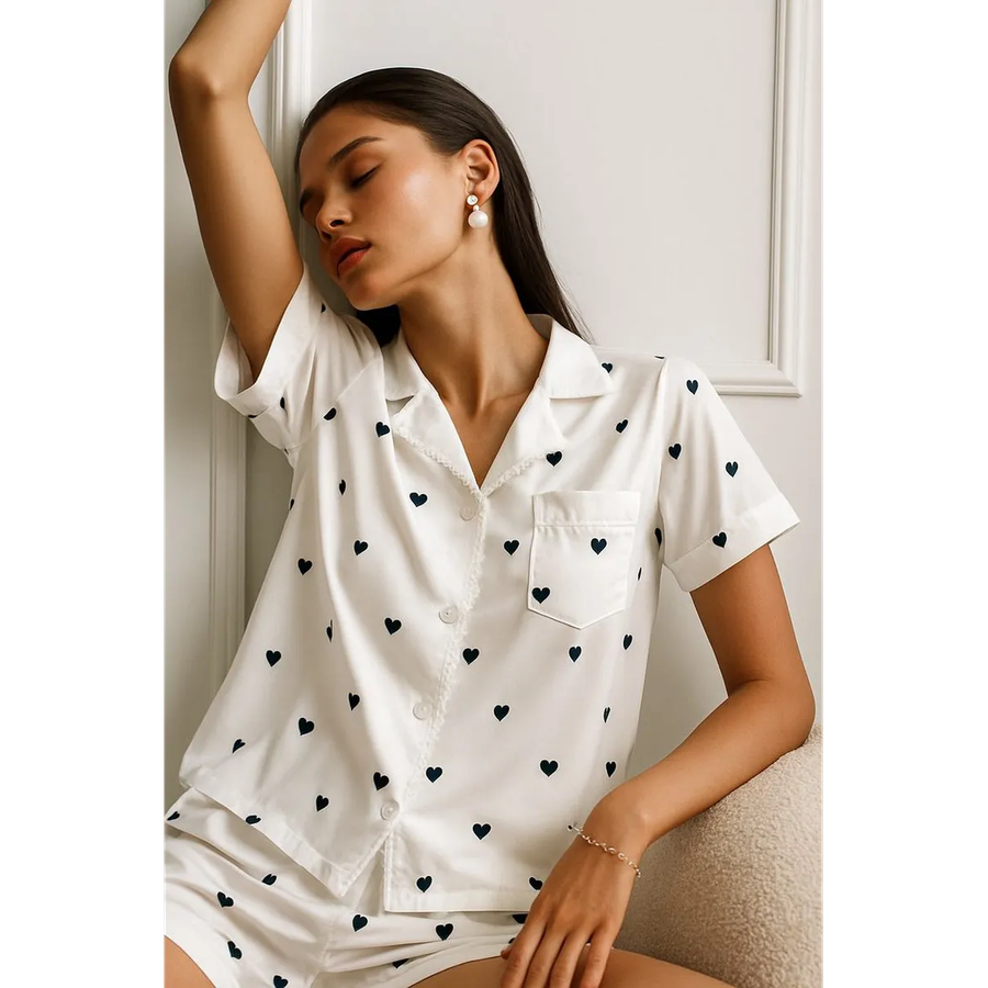 Donna che indossa set pigiama a cuori, maniche corte e pantaloncini, per un look notte rilassato ed elegante.
