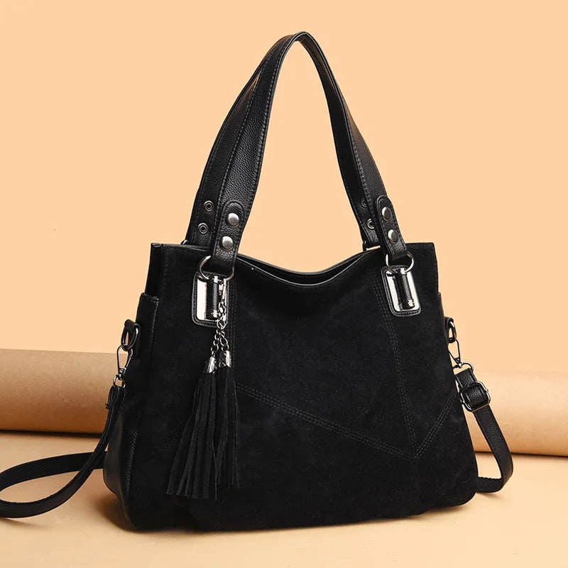 Borsa da donna strutturata, pelle e camoscio, con dettagli metallici discreti.