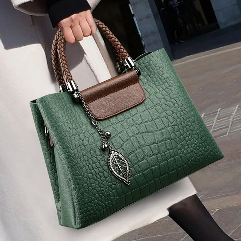 Elegante borsa a spalla donna in ecopelle con finitura coccodrillo e manici intrecciati, accessorio moda versatile.